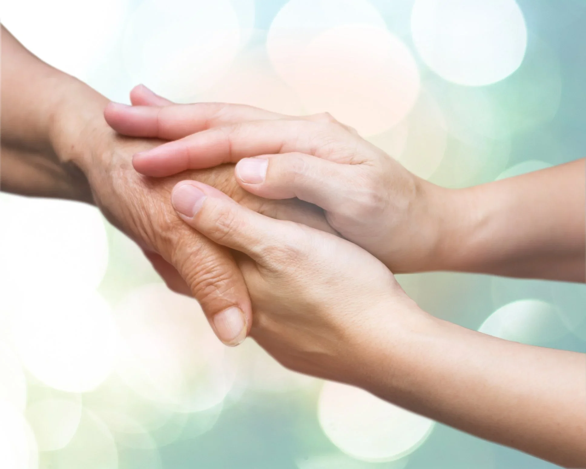 To hender, en ung og en eldre, som holder hverandre i hendene, symboliserer støtte og omsorg.