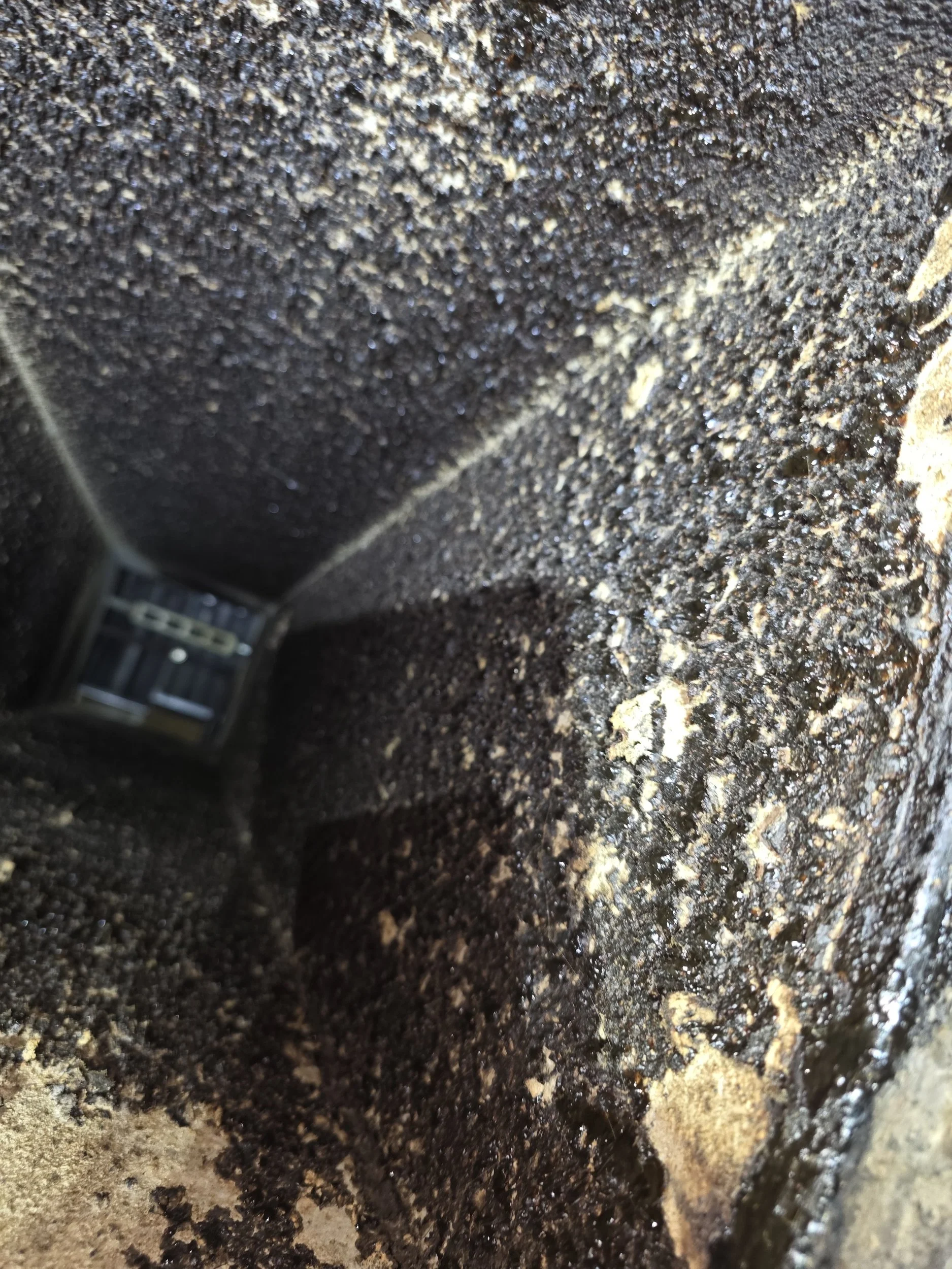 Heavy grease buildup inside a commercial kitchen exhaust system before cleaning.