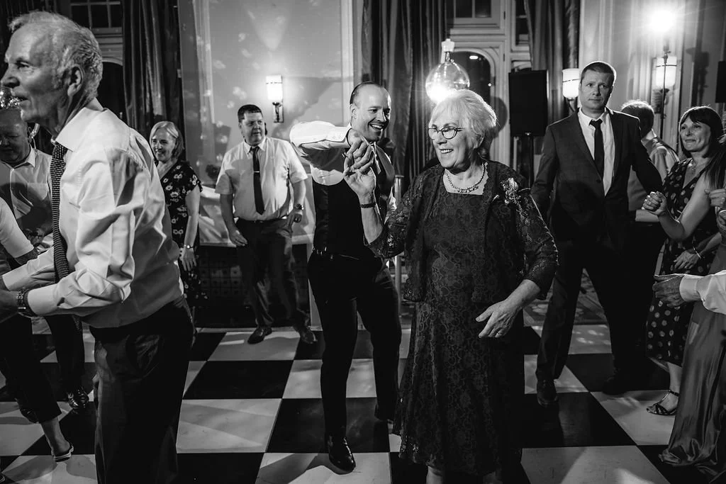 People dancing and enjoying themselves at a lively party in a decorated venue with elegant lighting.