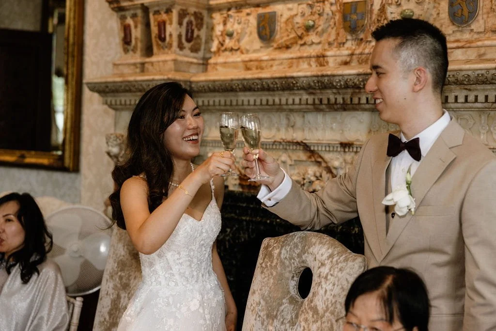A bride and groom clinking champagne glasses at their wedding celebration.