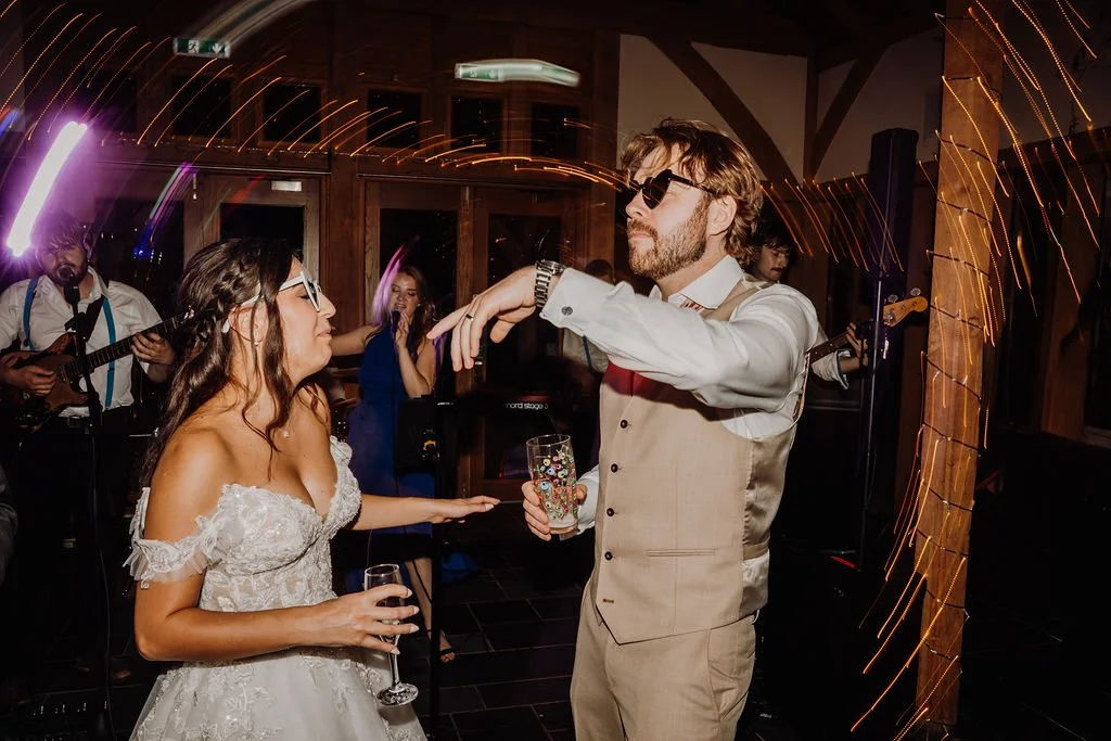 Bride and groom dancing at their wedding reception with live band playing in the background.
