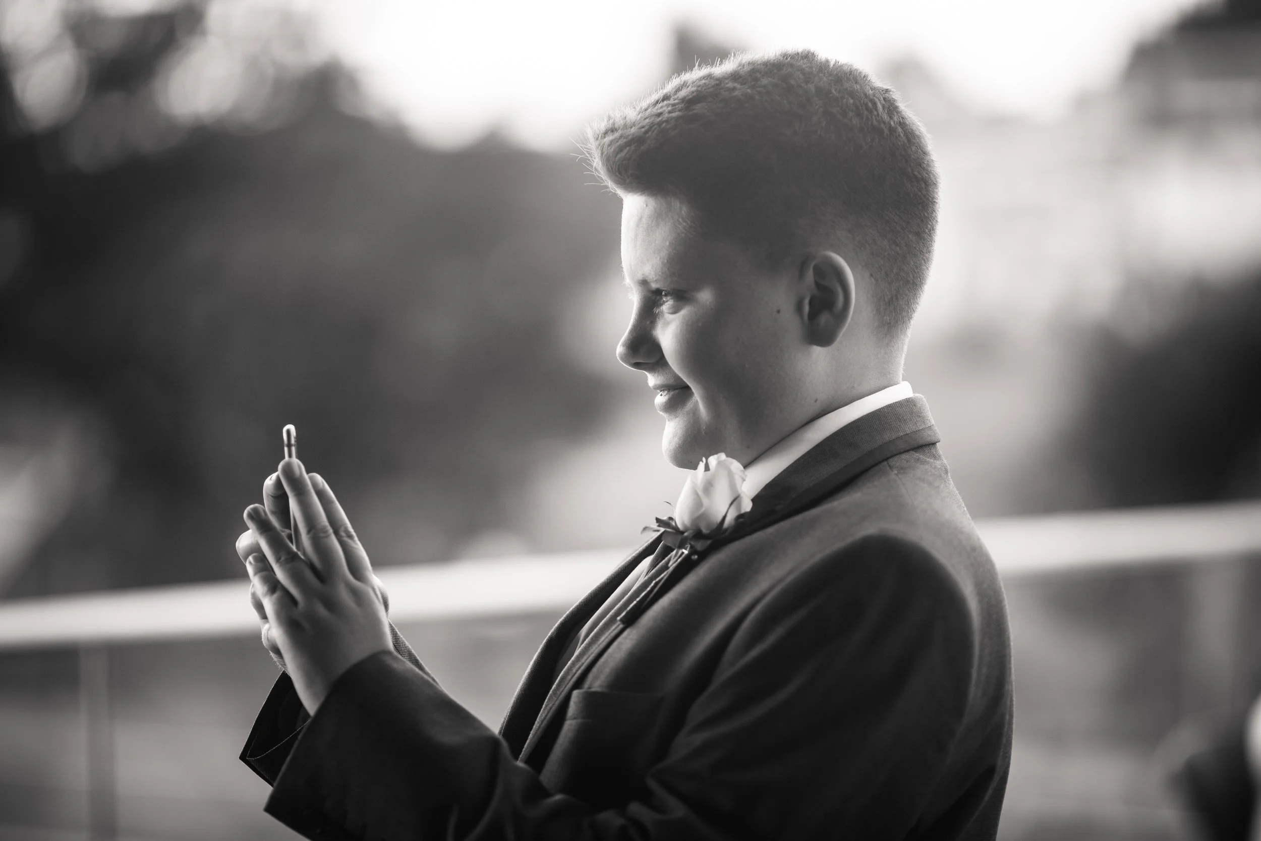 A young man in a suit holding a pill capsule in prayer.