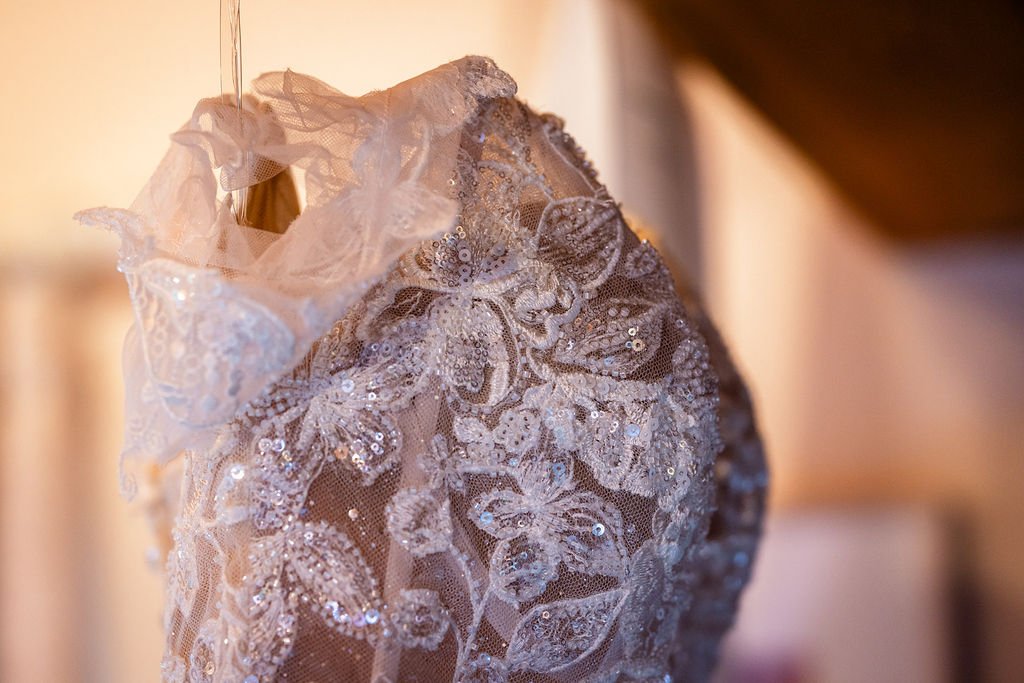 Close-up of a lace and sequined wedding veil or dress with floral embroidery.