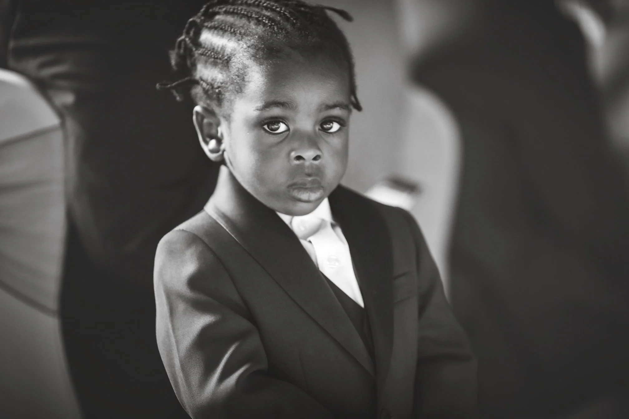 Little boy wedding guest with suit and braided hair