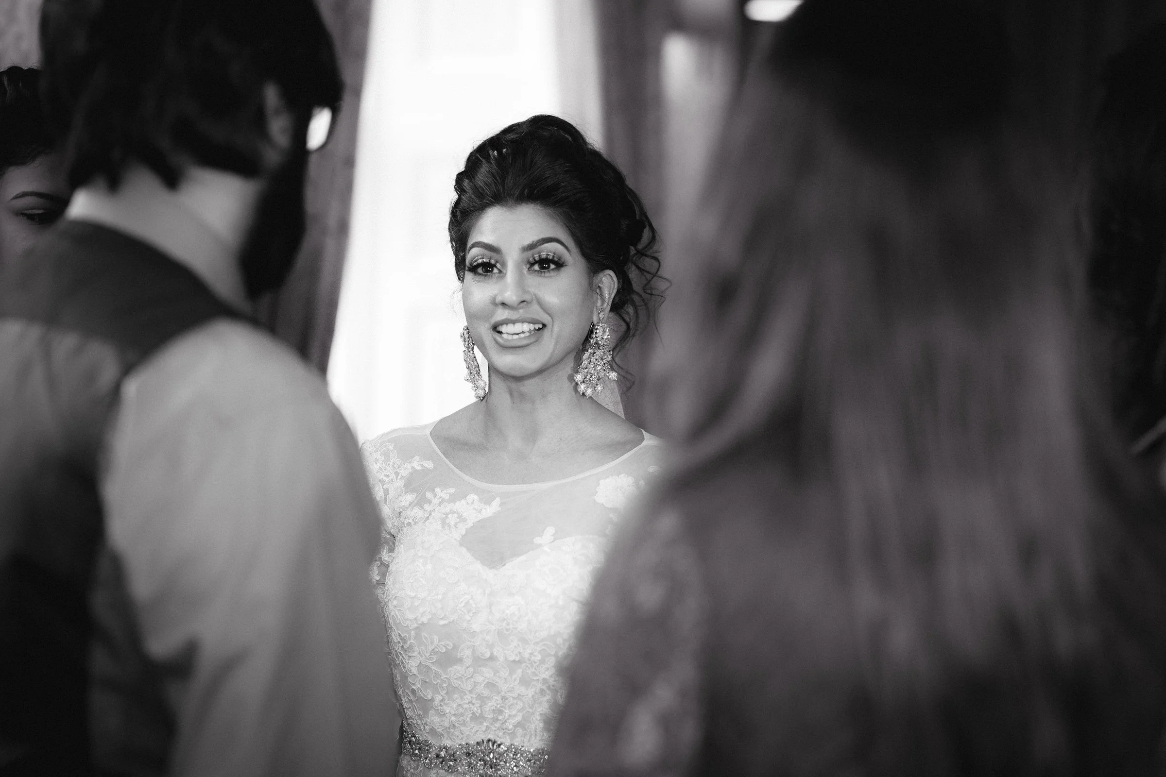 Bride chats to two wedding guests in the lounge area.