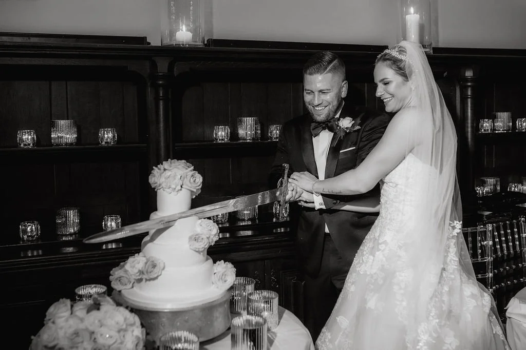A bride and groom are cutting a wedding cake together at their wedding reception.