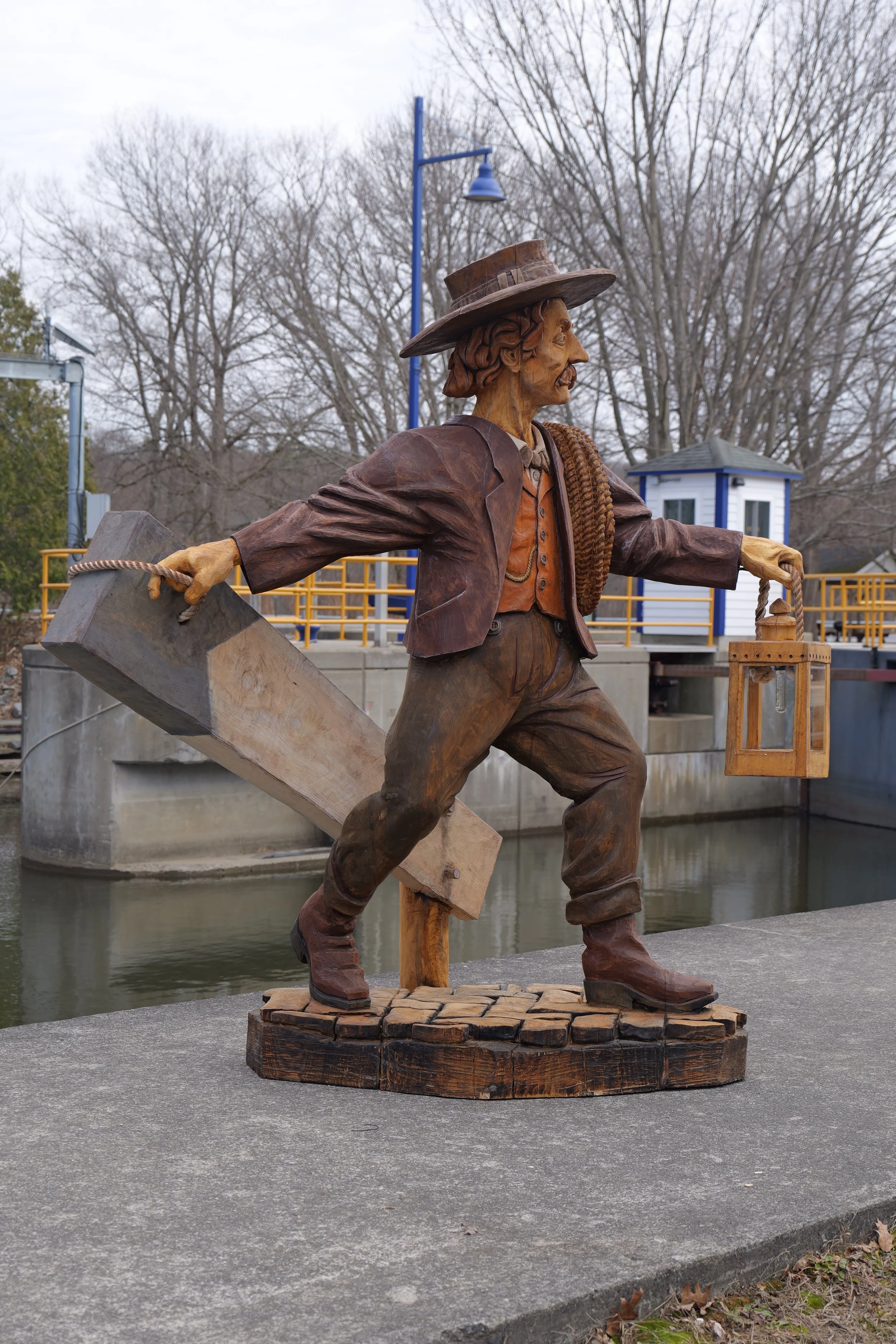 Pine Ridge Carvings. Custom chainsaw sculpture of a lock keeper raising the lock beam for the canal crossing.