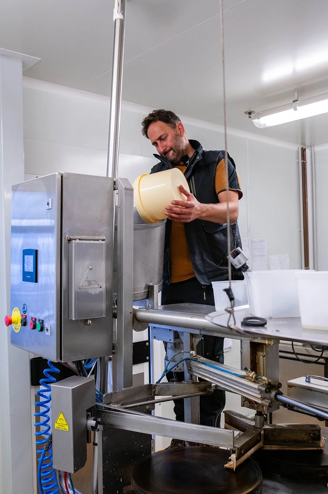 A man observes an industrial machine in a factory.