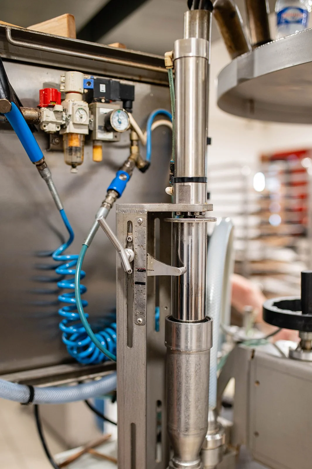 An industrial stainless steel machine with pipes, a pump, and pressures in a laboratory or factory environment.