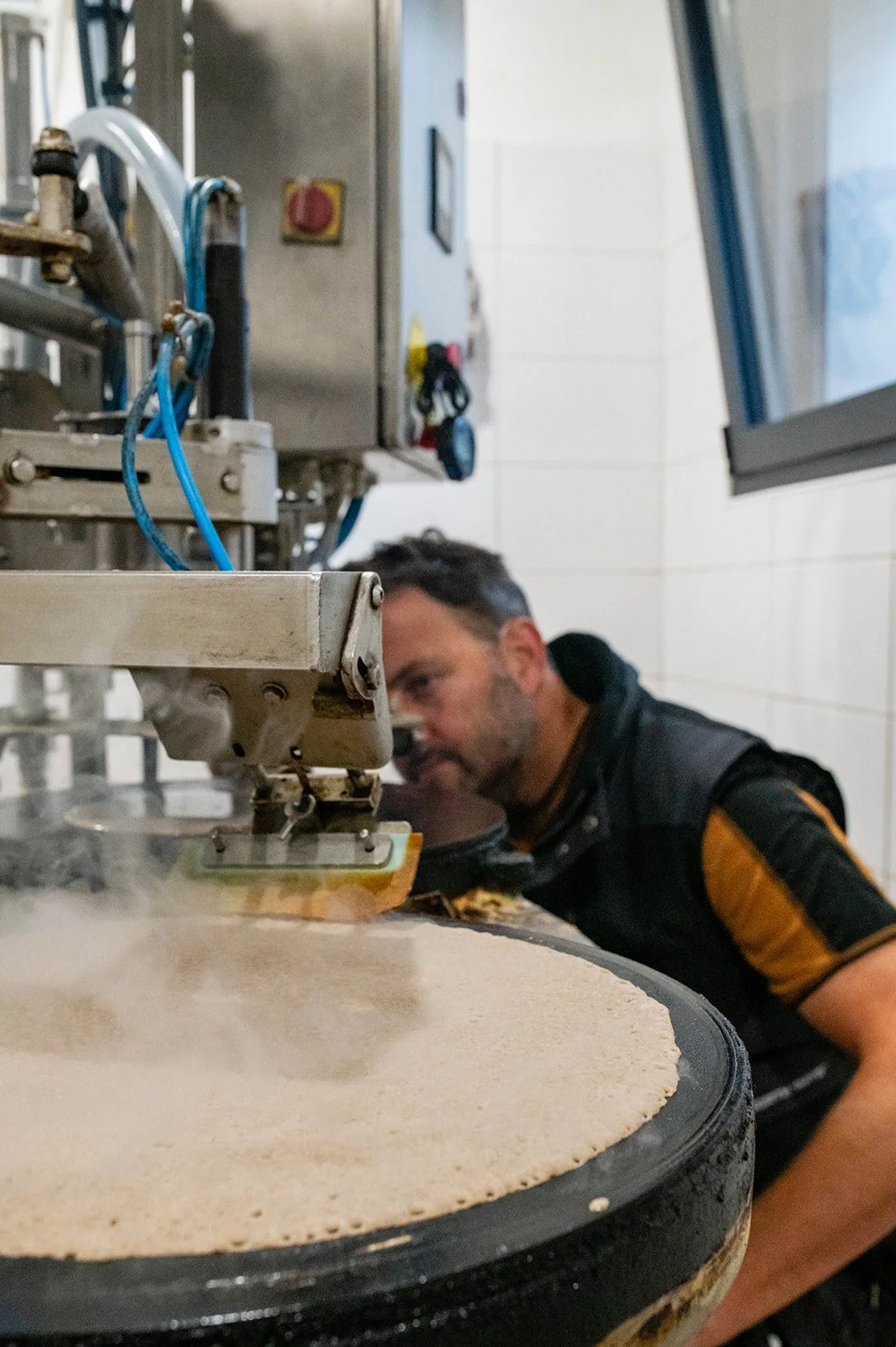 A man baking a pizza in a professional pizza oven.