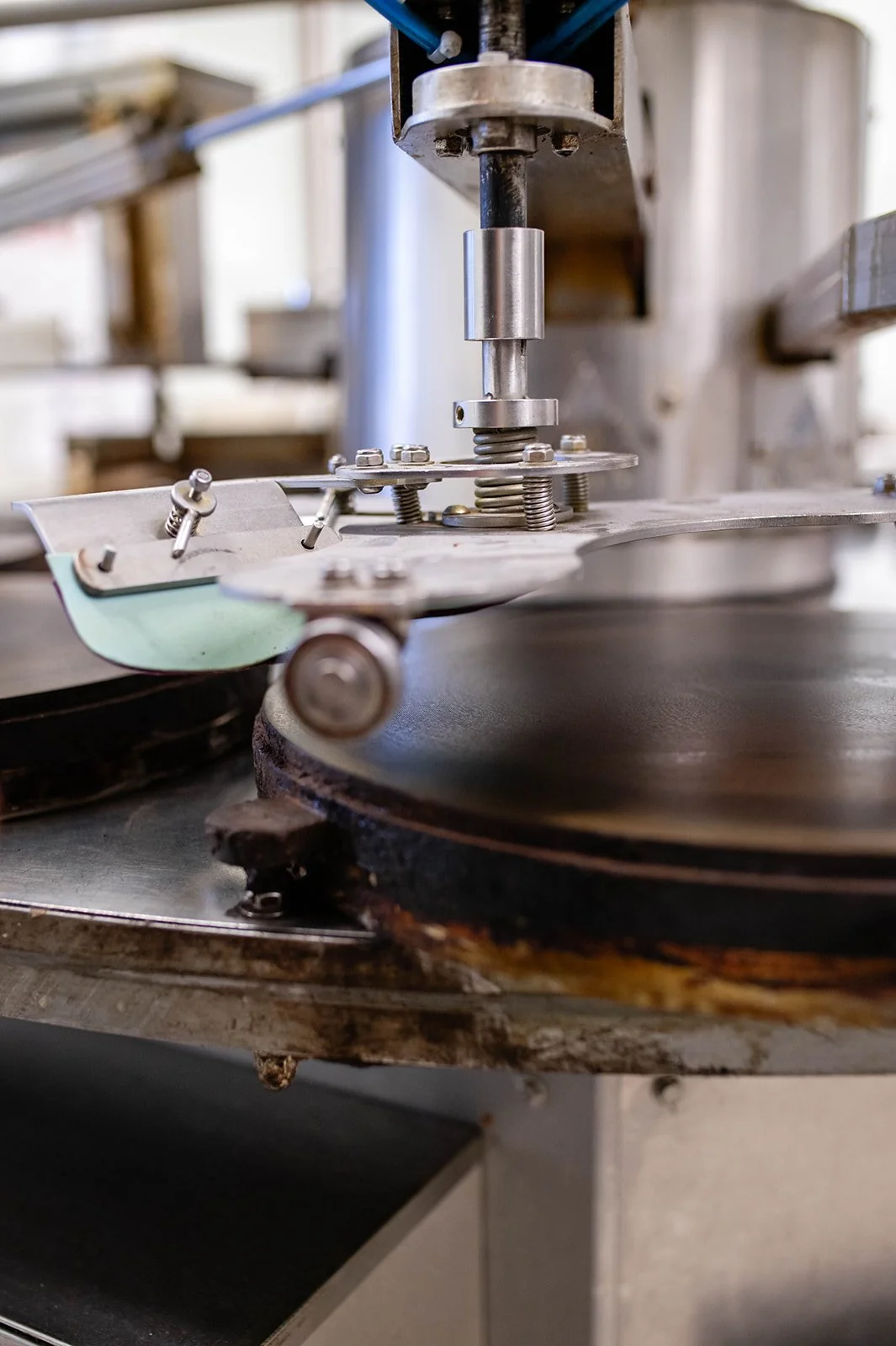 Manufacturing or sewing machine with metal components, rotating on a metal plate.