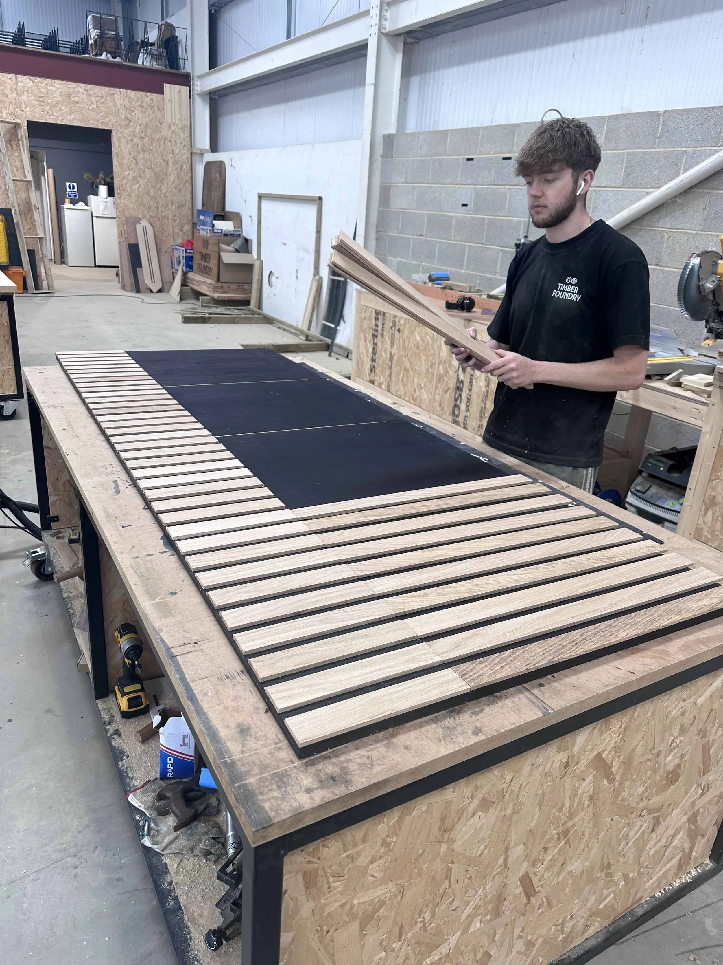 Joiner assembling precision-cut timber components for bespoke furniture