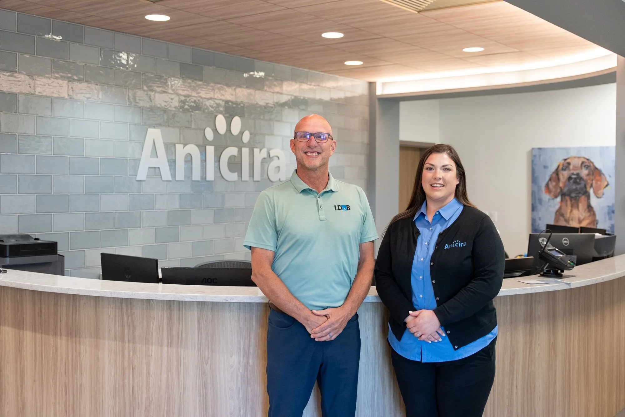 a LD&B representative and Anicira employee standing next to each other in front of the receptionist desk