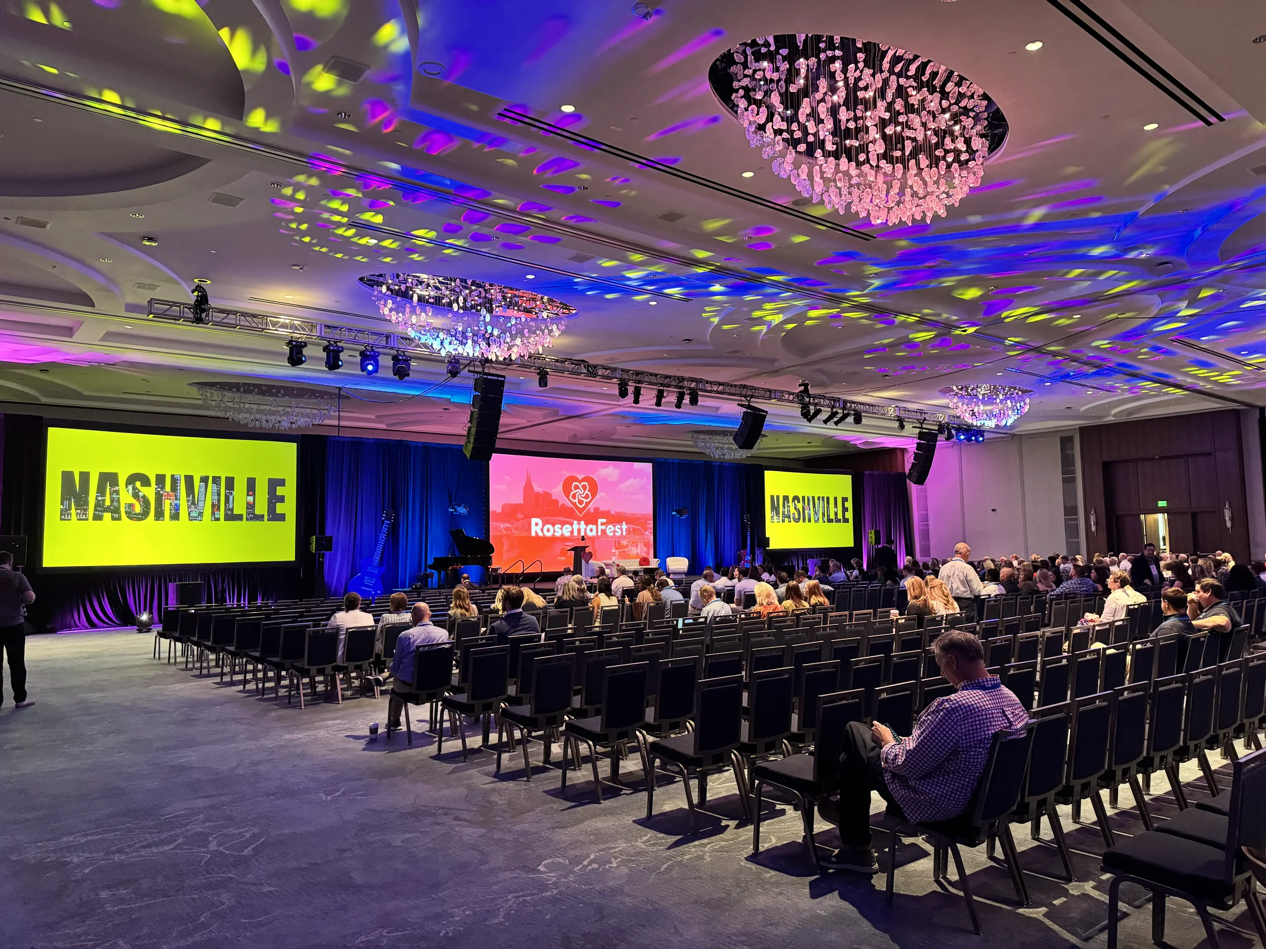 a banquet space holding the rosie awards with a bunch of chairs and individuals aimed toward the stage