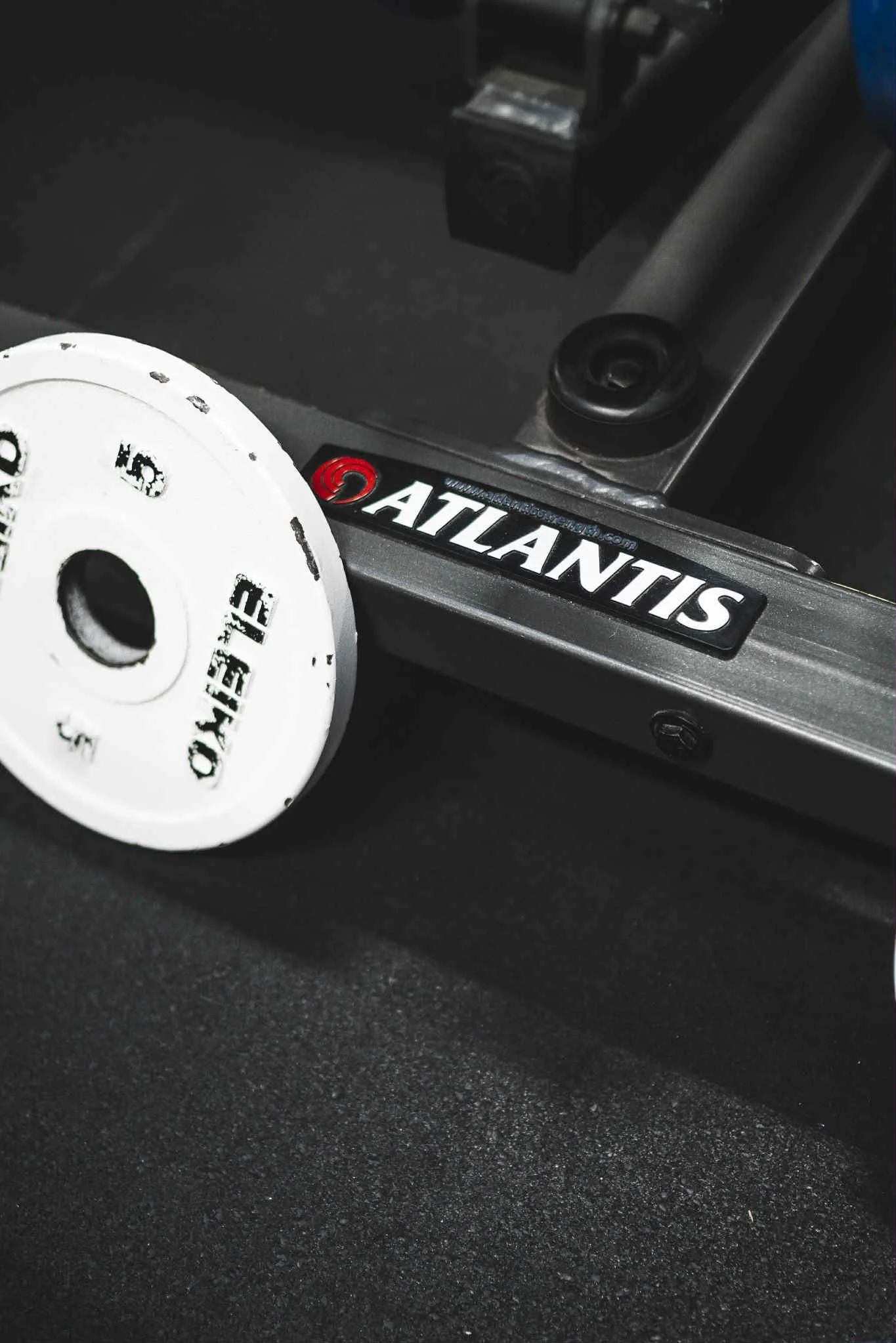 Resirkuleringsavfallsspole med hvit etikett foran en svart overflate med en Atlas-notat på en metallramme.