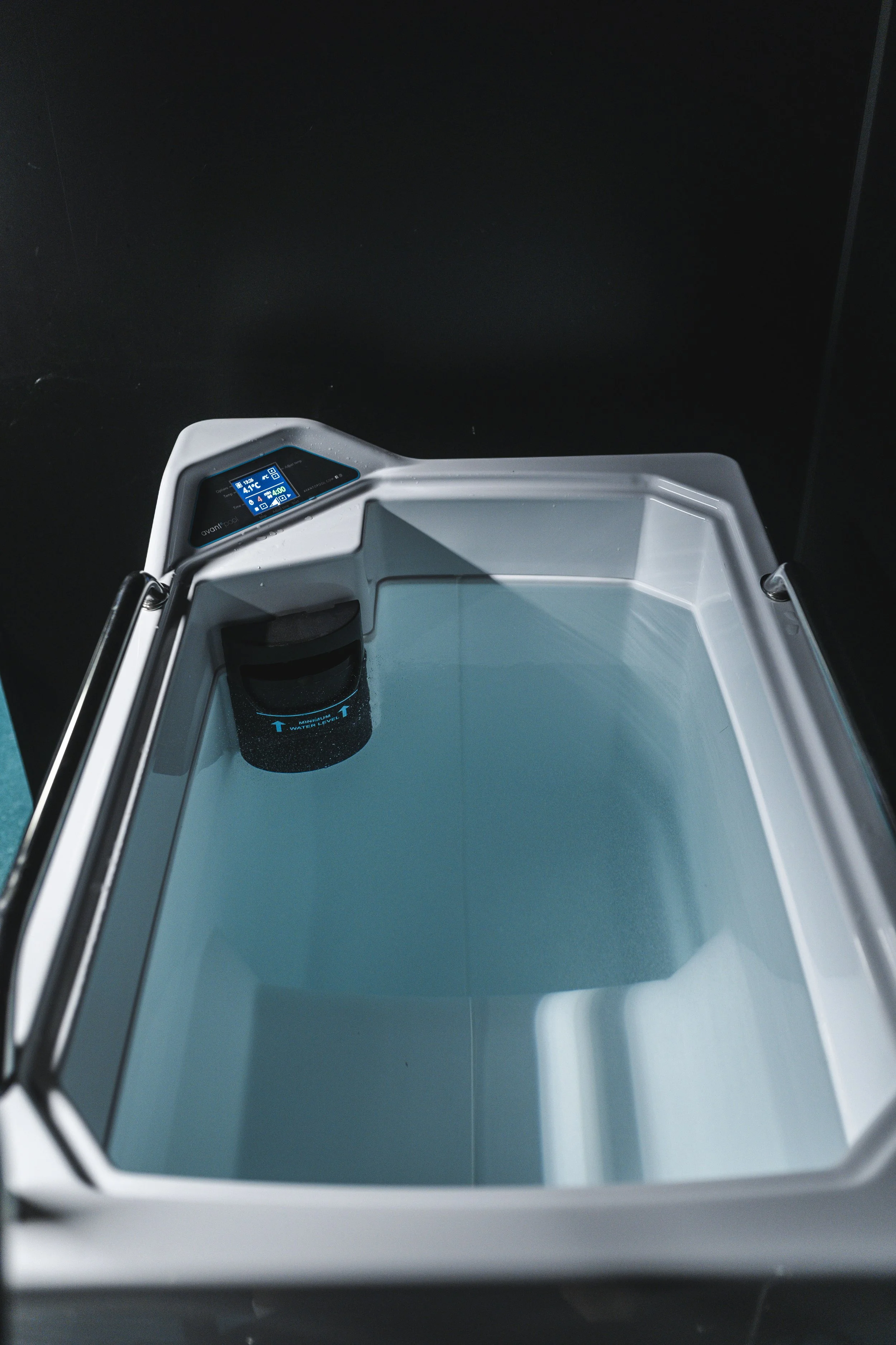 Et innendørs laboratorieinstrument med digital skjerm og en tom beholder med vann.