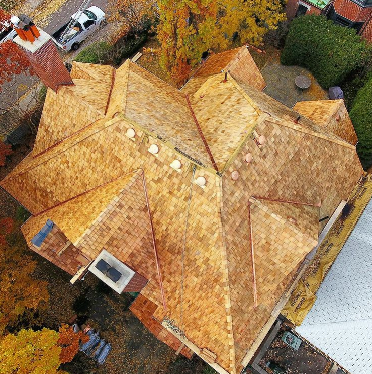 Aerial view of a large house with a complex, multi-gabled, cedar shingle roof installation