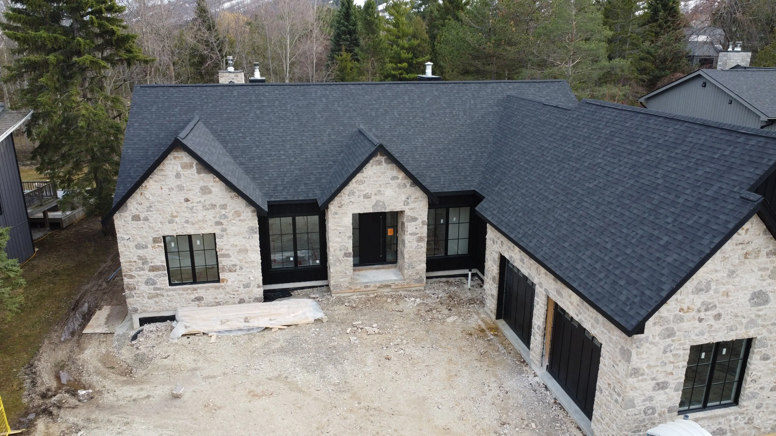 An aerial view of a custom home with asphalt shingles on the roof that our crew installed