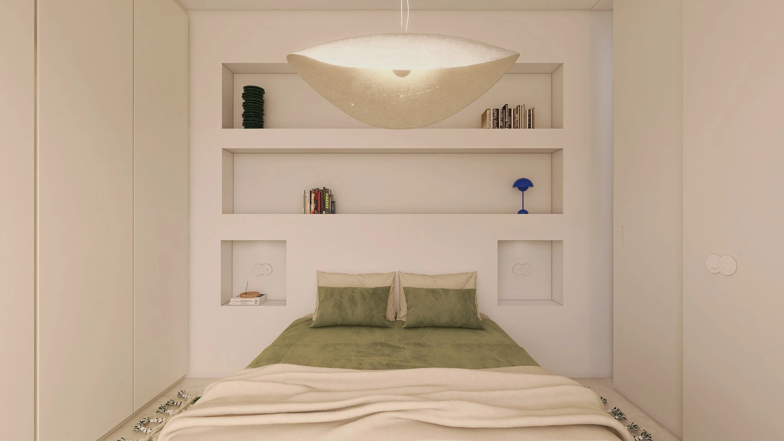 Dormitório com cama de roupa verde e travesseiros bege e verde, nichos na parede com livros, uma pequena luminária azul e uma luminária de teto moderna