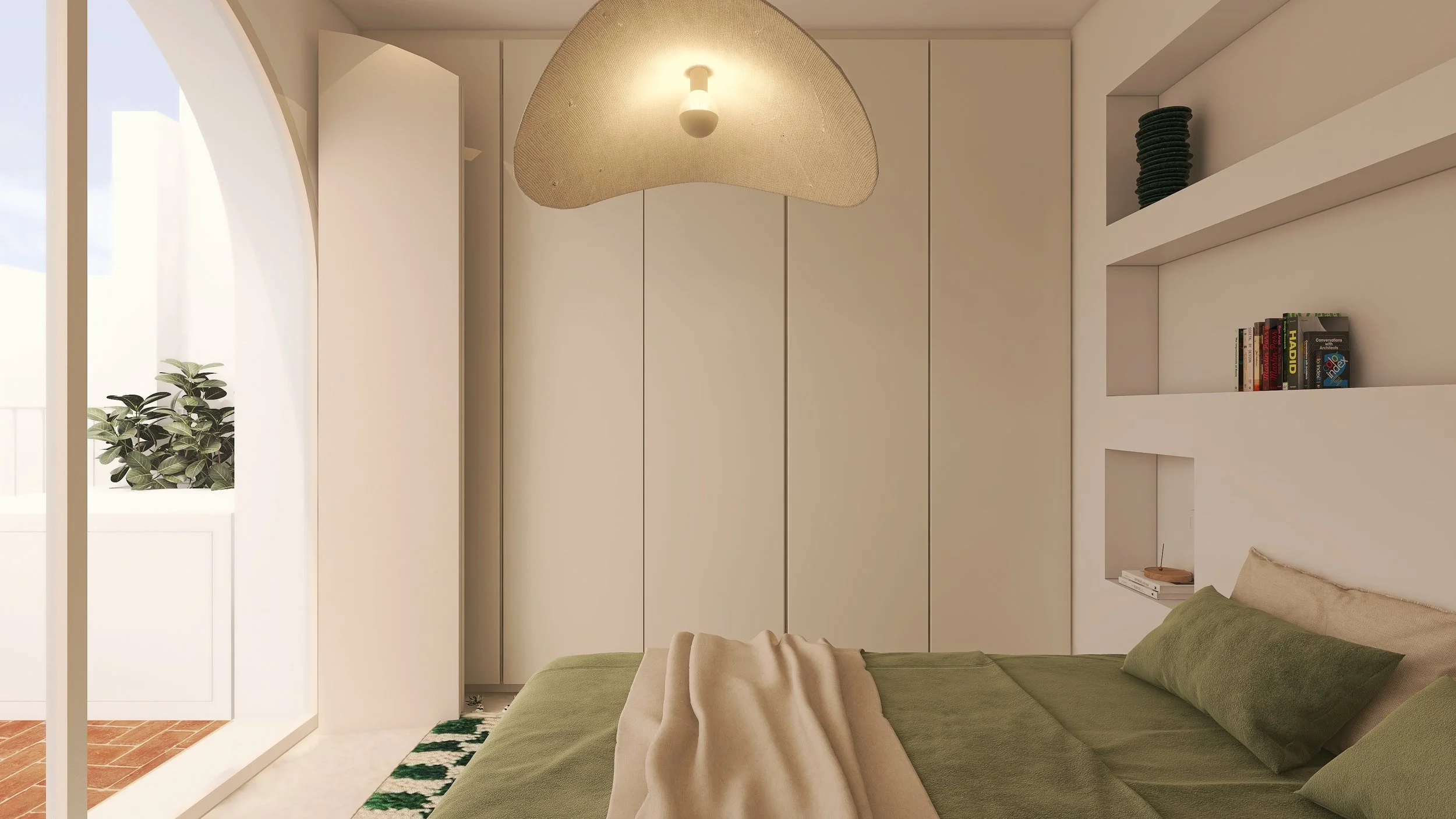 Quarto com cama de casal com roupa de cama verde, prateleiras brancas com livros, abajur de teto com cúpula de tecido, janela com plantas no varanda ao lado, paredes brancas e piso de ladrilho vermelho.