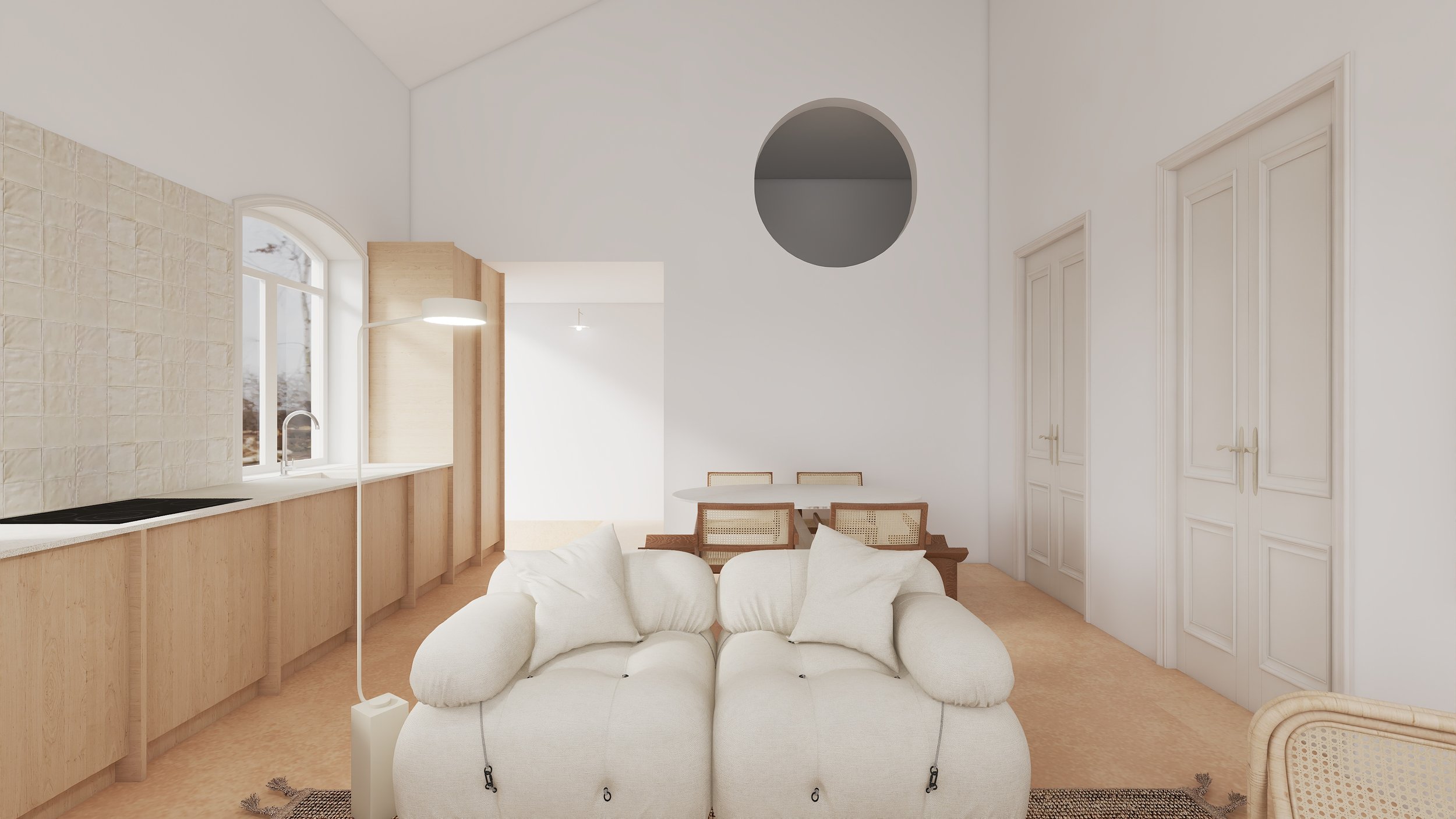 Sala de estar com sofá branco, mesa de jantar com cadeiras de palha, cozinha com bancada de madeira, janelas grandes e paredes brancas.