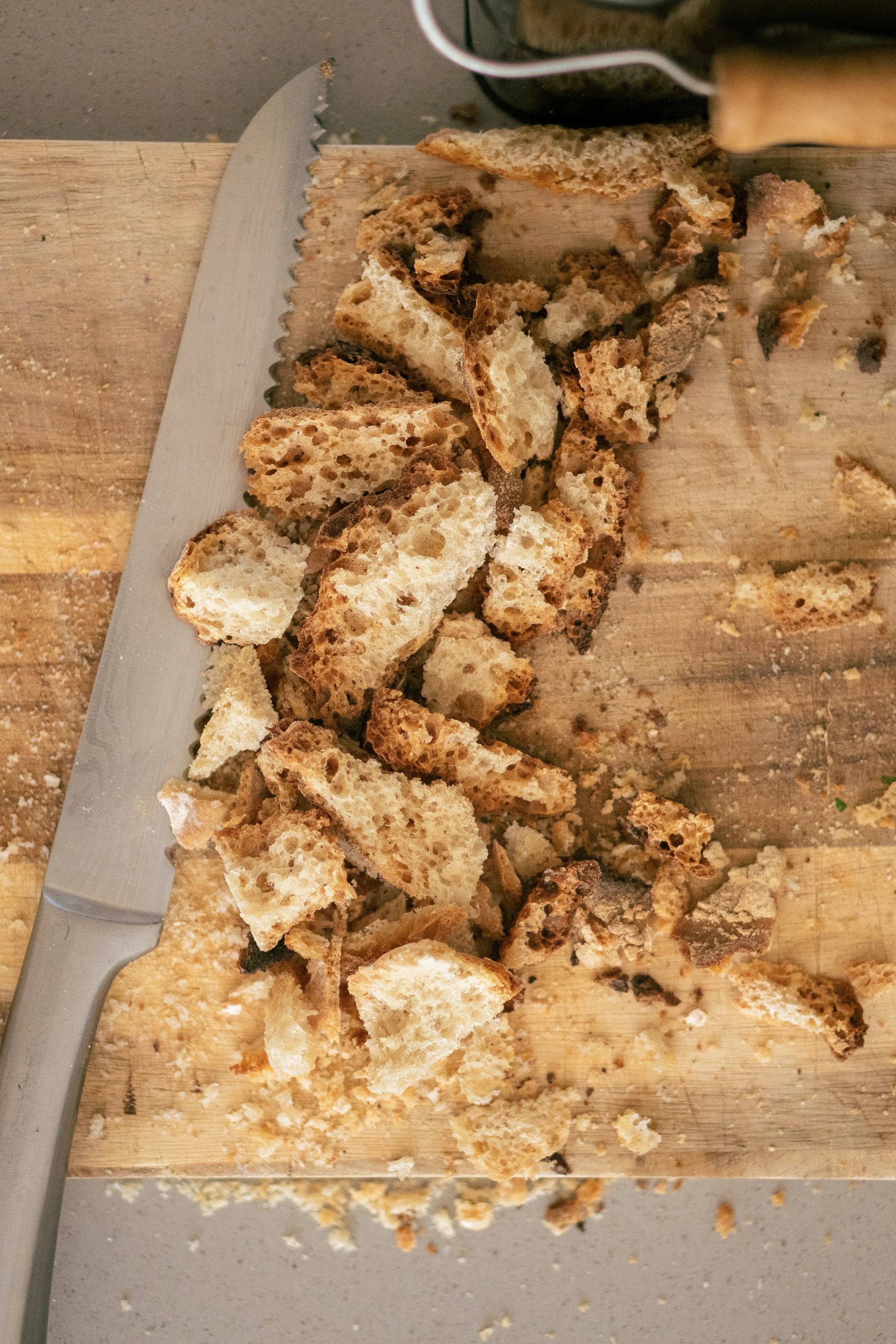 Breadcrumbs on a breadboard with serrated knife