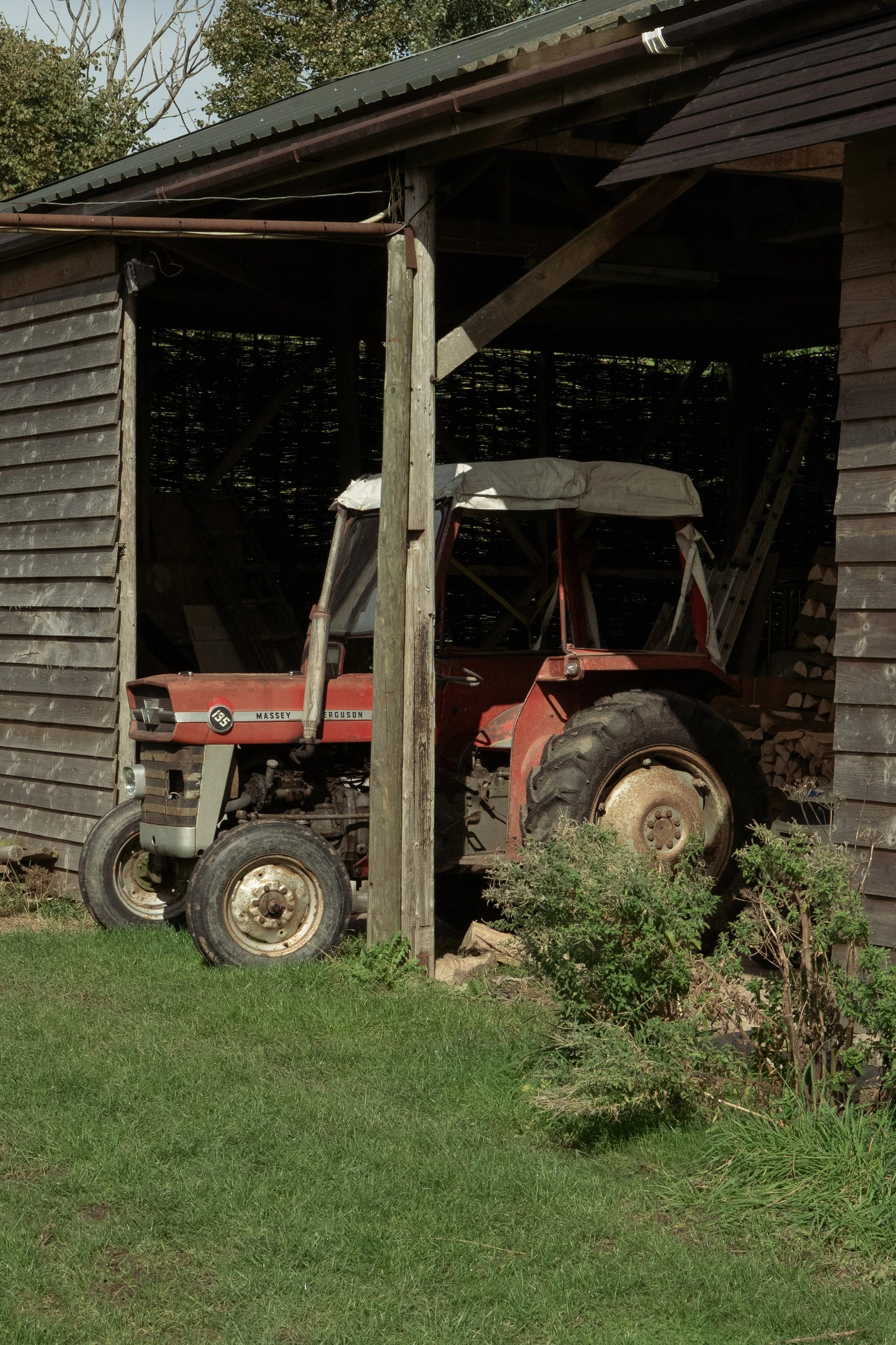 Red tractor, peaking out from a farm shed 