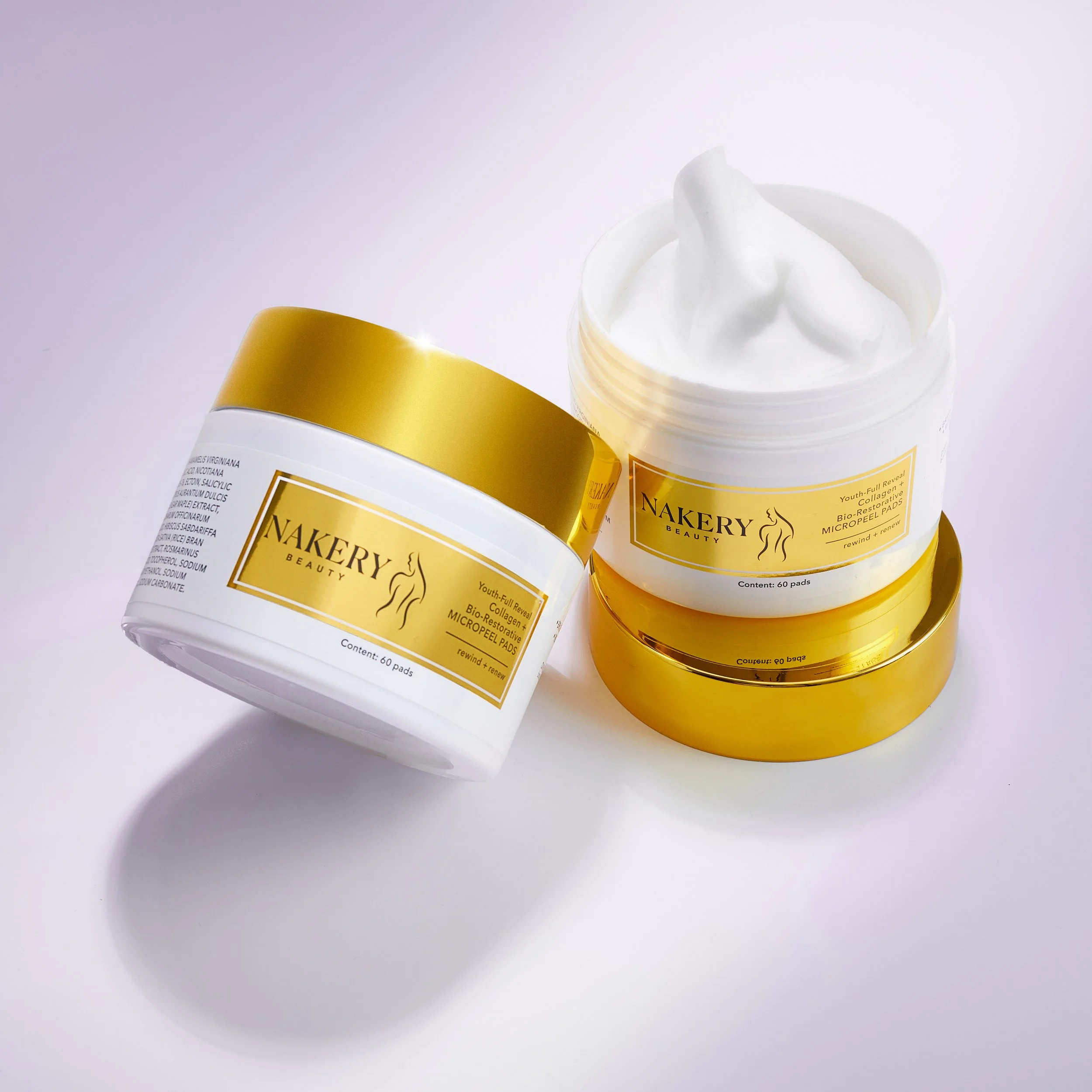 Open container of Nakery Beauty anti-aging cream with the lid placed next to it on a white surface