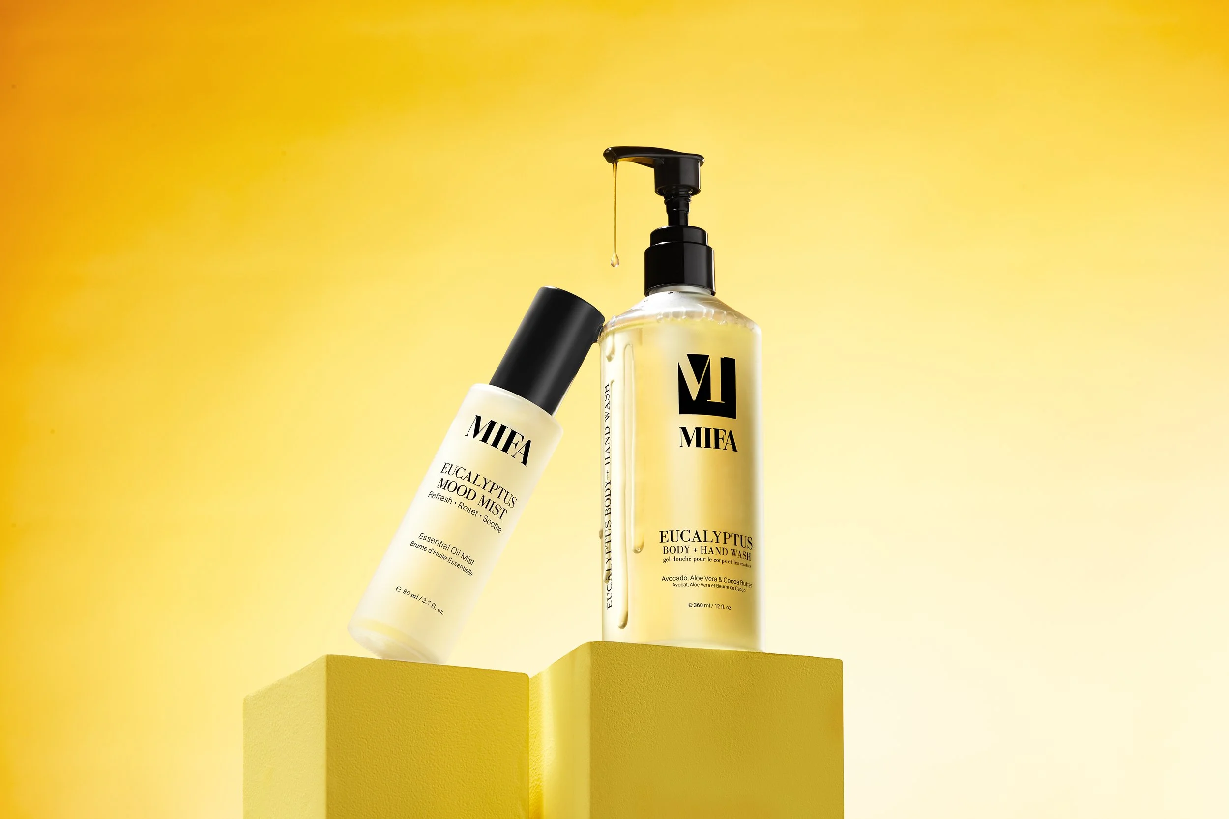 Two skincare bottles labeled 'MIFA', one with a pump dispenser and one with a spray top, placed on yellow pedestals against a yellow gradient background.