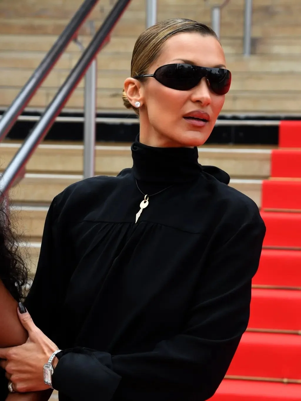 Two years after donning a vintage red and white keffiyeh dress at Cannes, Bella Hadid gave another nod to her Palestinian roots at the film festival wearing a gold key of return necklace. 

The key pendant, which has teeth cut in the shape of Palesti