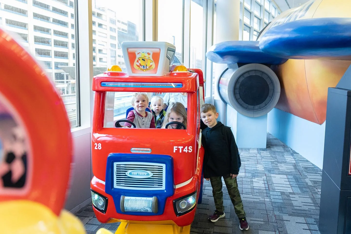 Four children smiling in the children's play area in MSP Airport's  Terminal 1