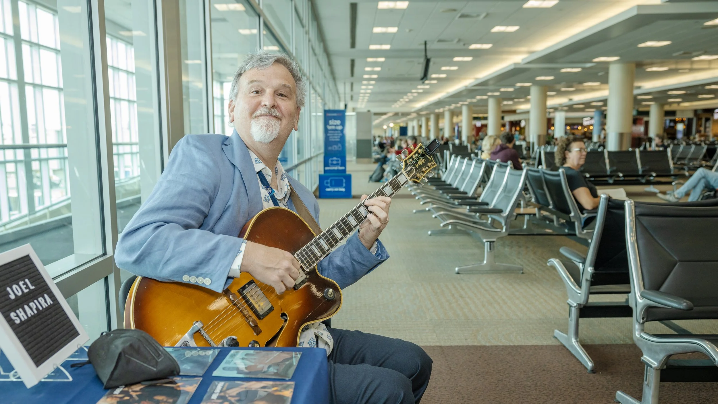 Weekly Performer with guitar at a gate in MSP Airport's Terminal 2
