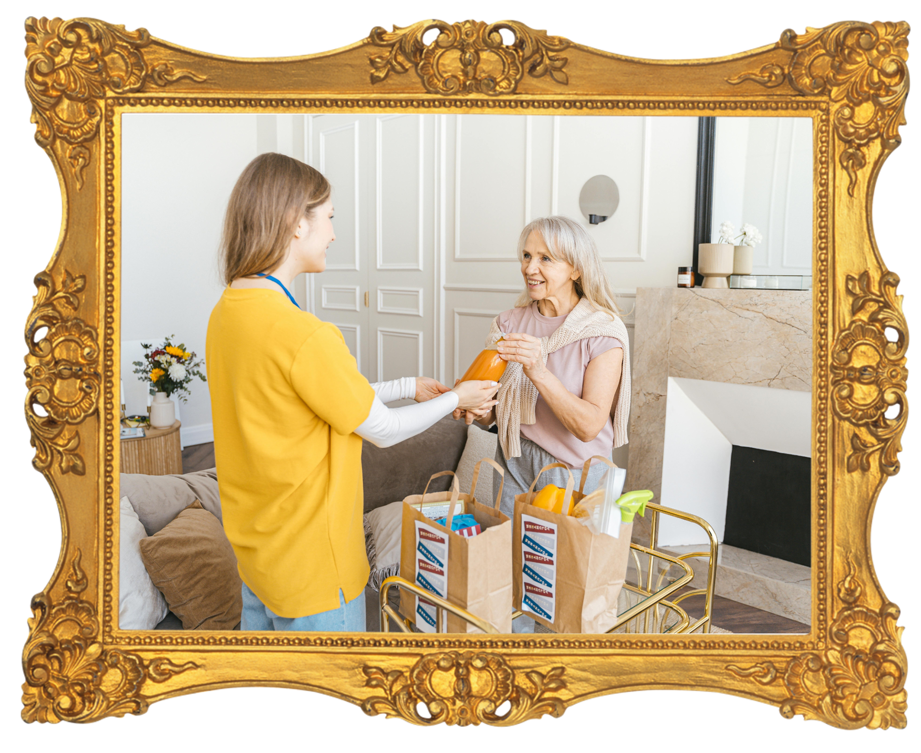 A young woman delivering groceries to an older woman at her home, both smiling. The young woman is handing a bottle of orange juice to the older woman, who is reaching out to receive it. The scene takes place in a stylish room with white paneled walls and a beige marble fireplace. Grocery bags filled with various items are on a gold cart.