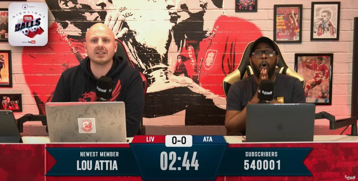 Red men tv watching a live Liverpool Game whilst they are being sponsored by the testicular cancer "highlight your balls" campaign, shown by a logo in the top left corner