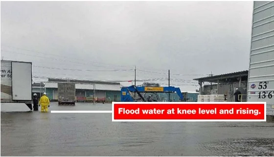 Flooded street with vehicles and a person in yellow rain gear, with a caption about rising flood water at knee level.
