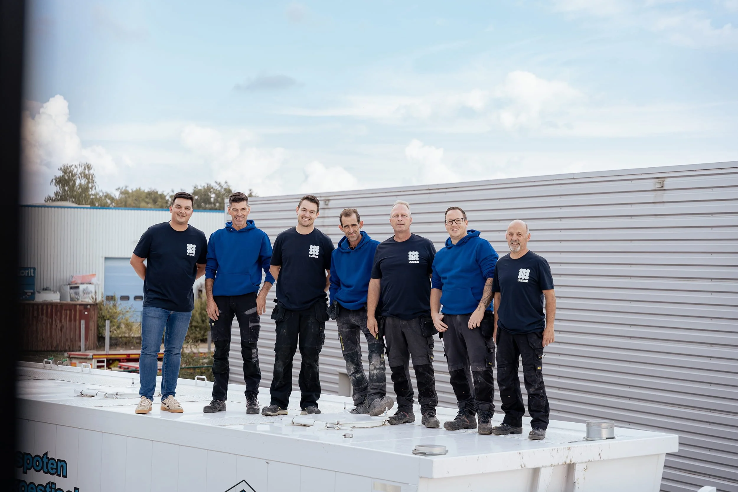 L’équipe de Ludiso pose ensemble sur le dessus d’un camion sur le site de l’entreprise.