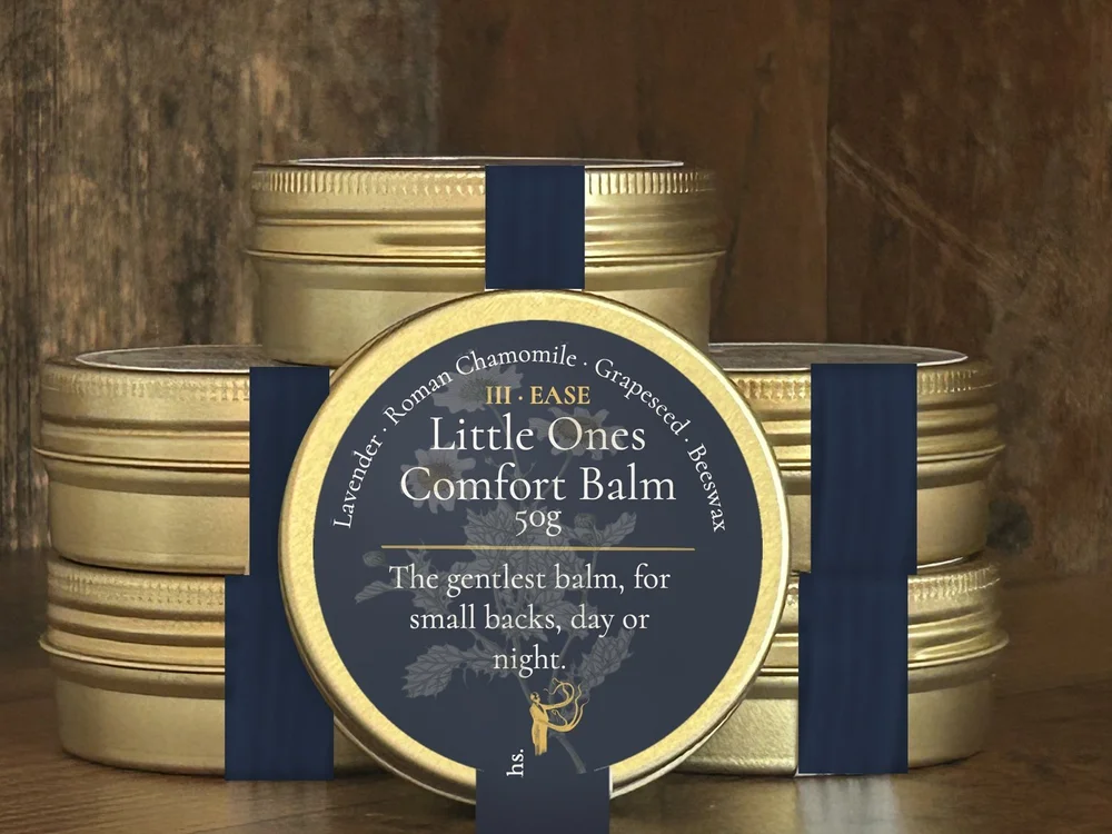 Little Ones Comfort Balm in small tins with navy band labels