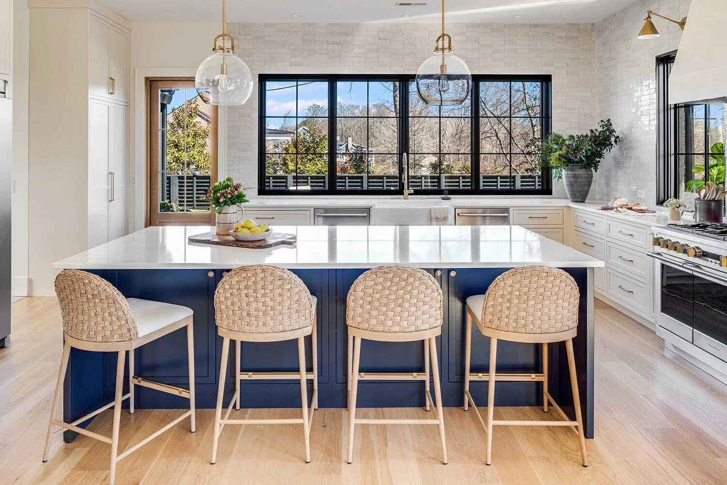 Kitchen Remodel Greenville SC view of island seating, range hood, panoramic windows, door to patio.webp