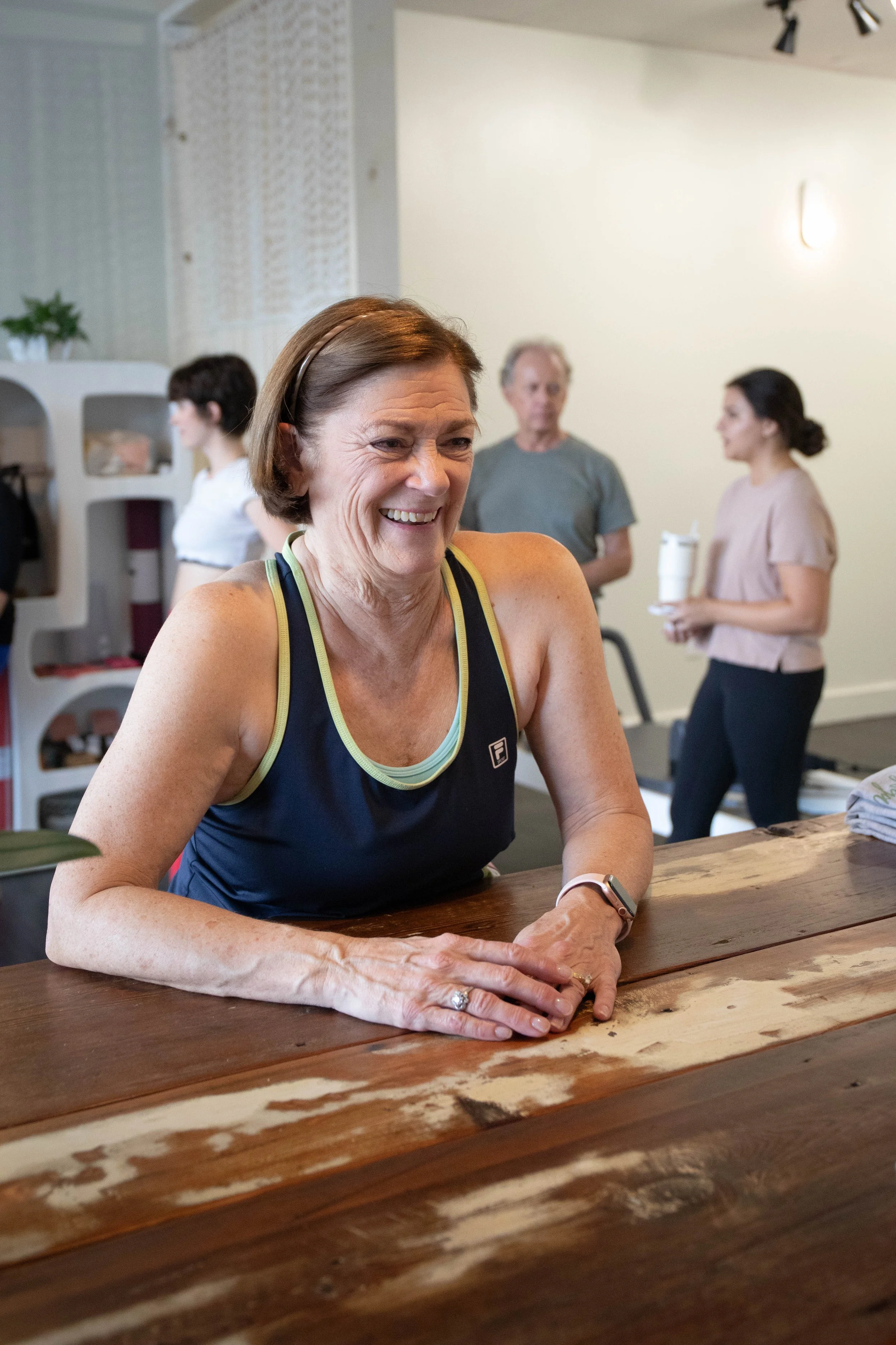 Pilates student smiling while leaning on front desk