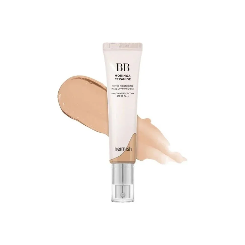 Tube of Helmesh BB cream with beige and light pink swatches behind it on a white background.