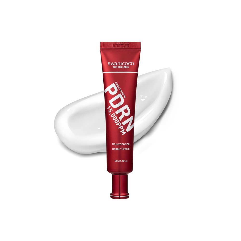 Red tube of SWANICOCO PDRN rejuvenating repair cream with white cream smear behind it on a white background.