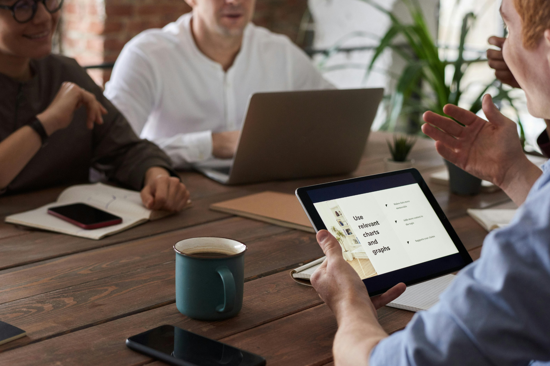 Leadership coach facilitating small-team strategy discussion during leadership development workshop.