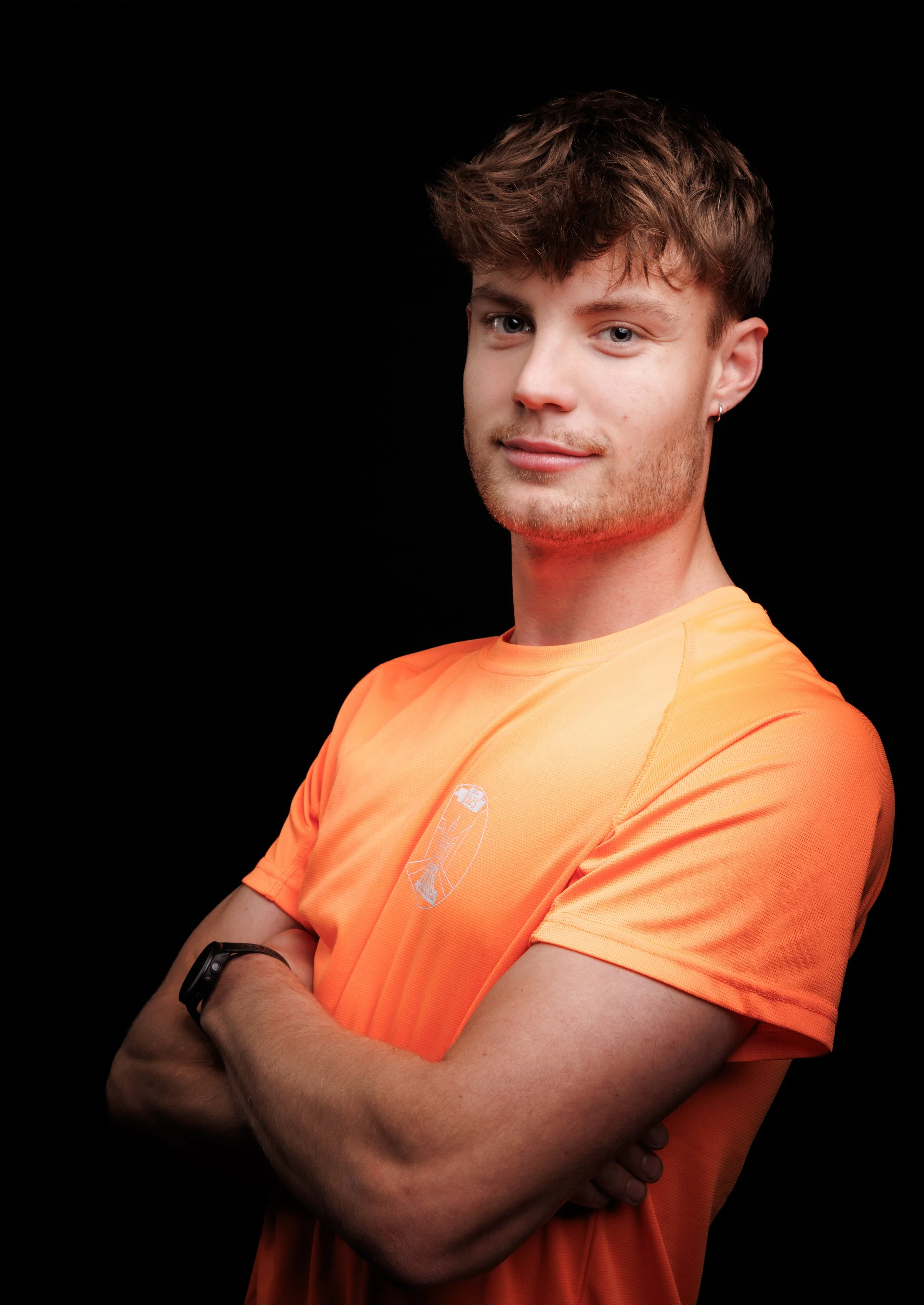 Lignes de coureurs prêts à démarrer une course dans une rue urbaine, avec des spectateurs et des bâtiments en arrière-plan.