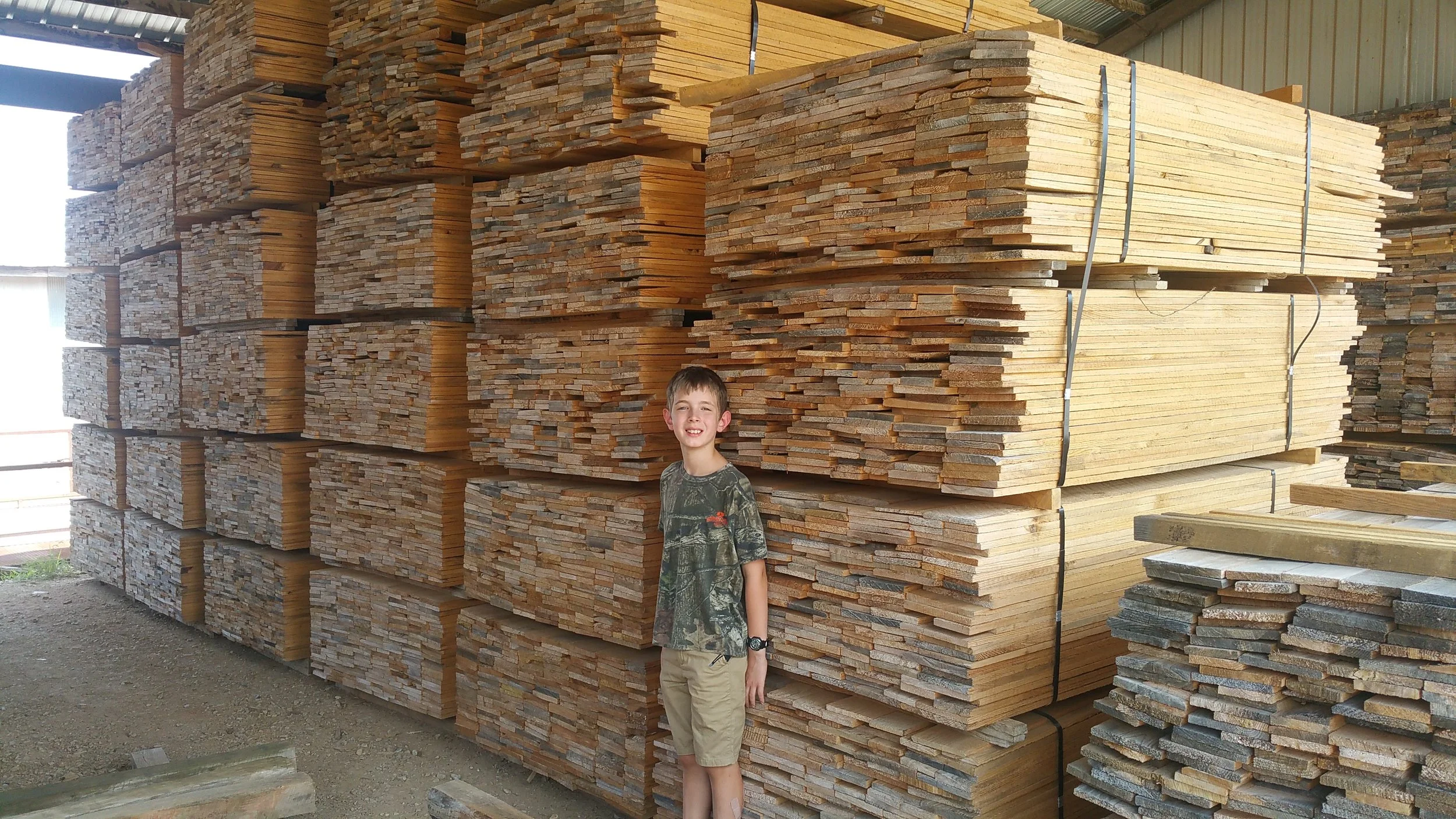 Modern building with wood exterior and large glass window in a mountainous landscape.