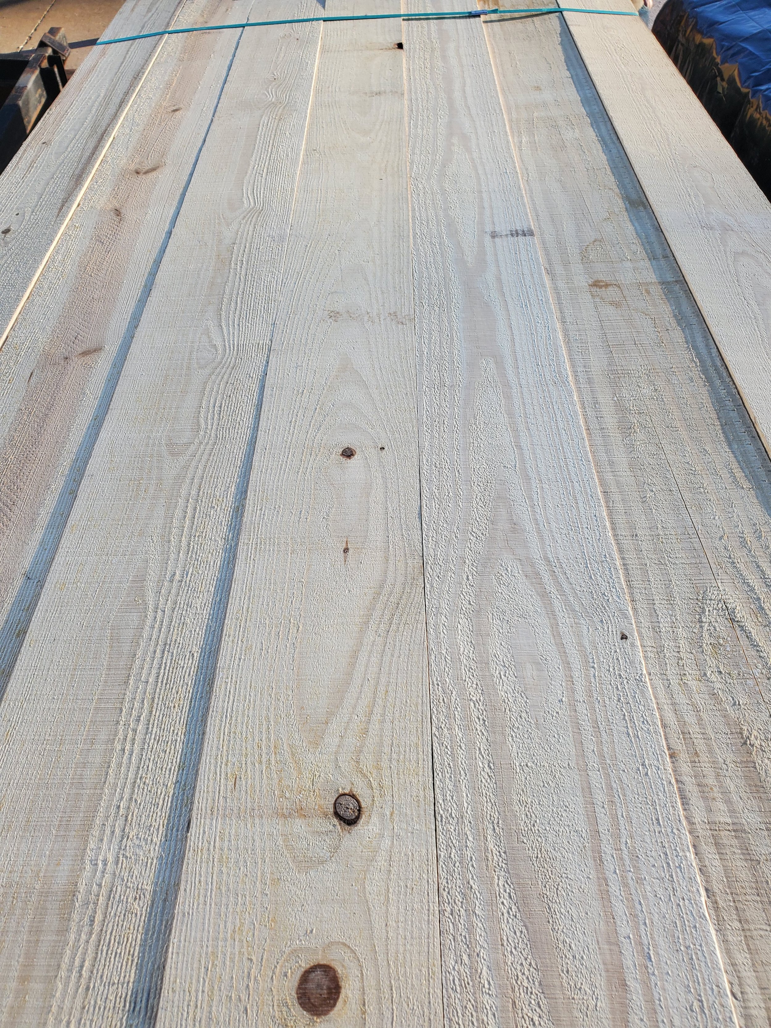Scenic mountain landscape with rugged, snow-capped peaks in the background and a modern wooden building on a green hillside in the foreground.