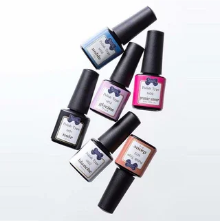 Six bottles of nail polish in various colors, arranged in a scattered pattern on a white background.