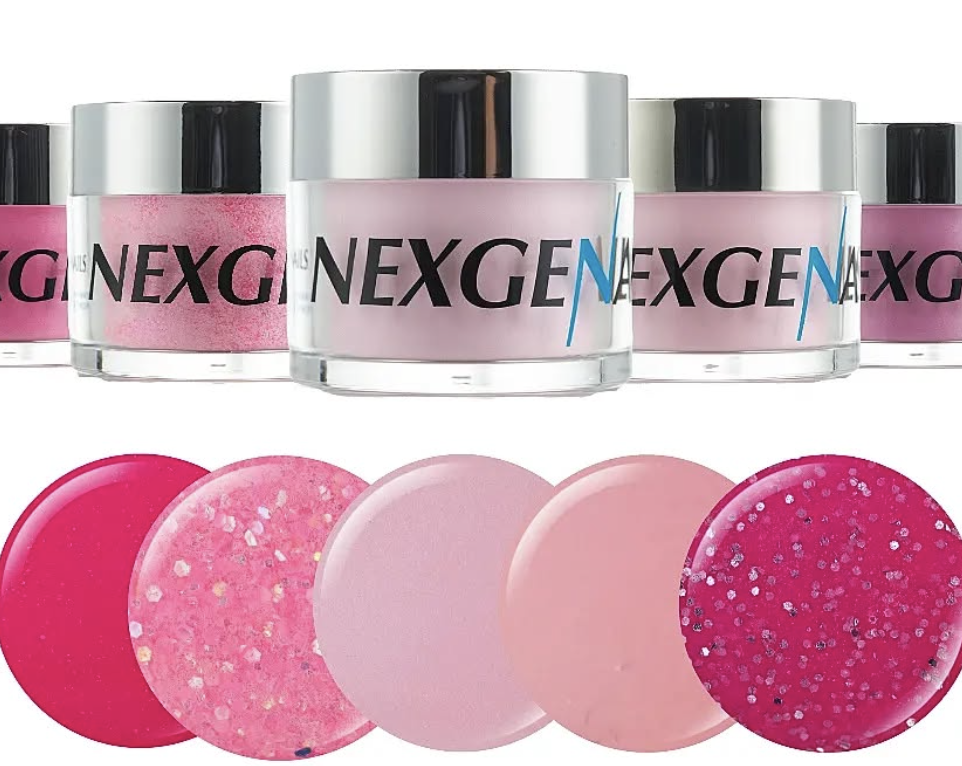 Collection of pink and pastel-colored skincare or cosmetic jars and round pads, with colorful glitter on some, arranged in a row.