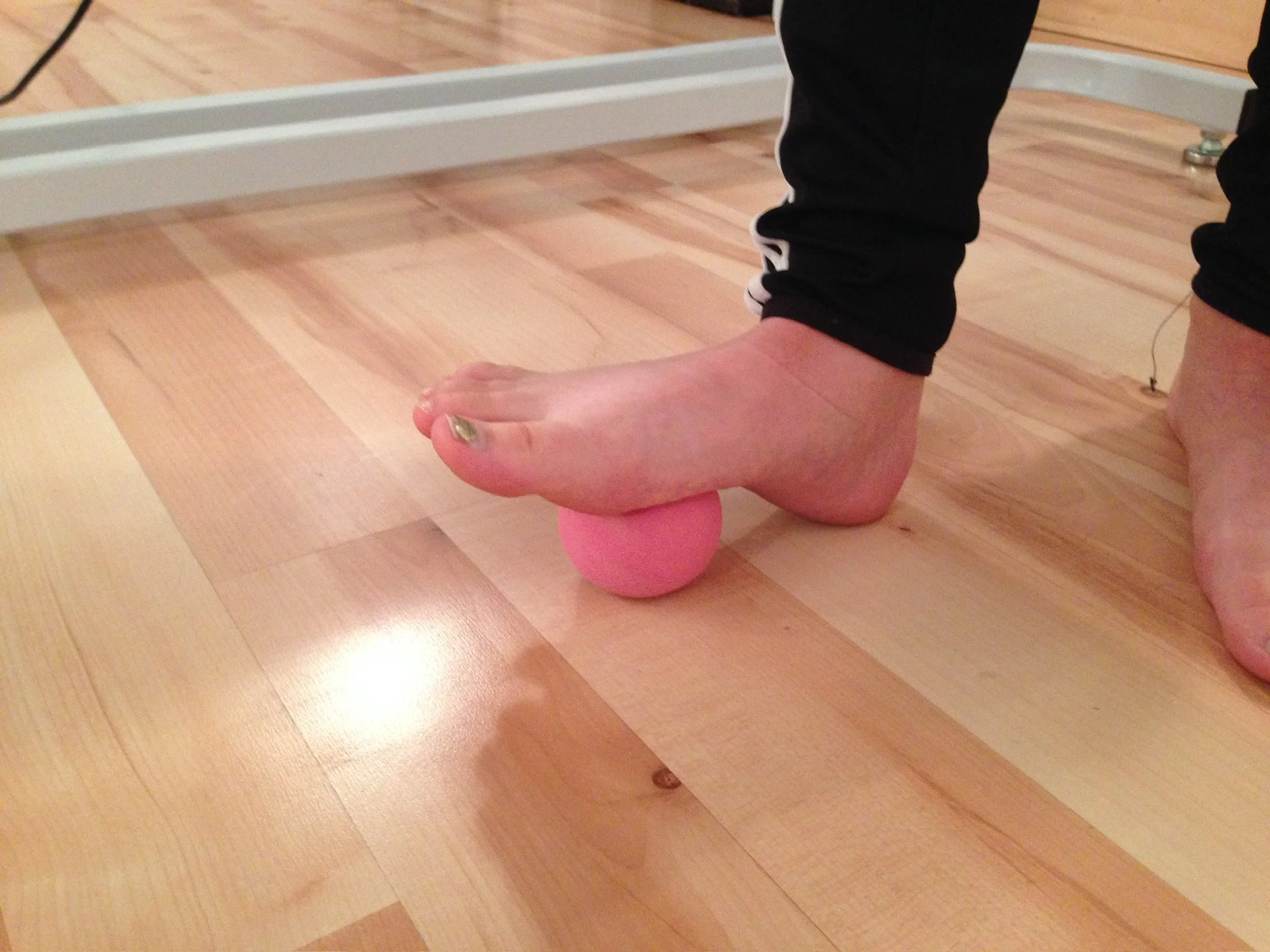 Ball of the foot rolling on a small ball to encourage foot movement and pressure awareness.