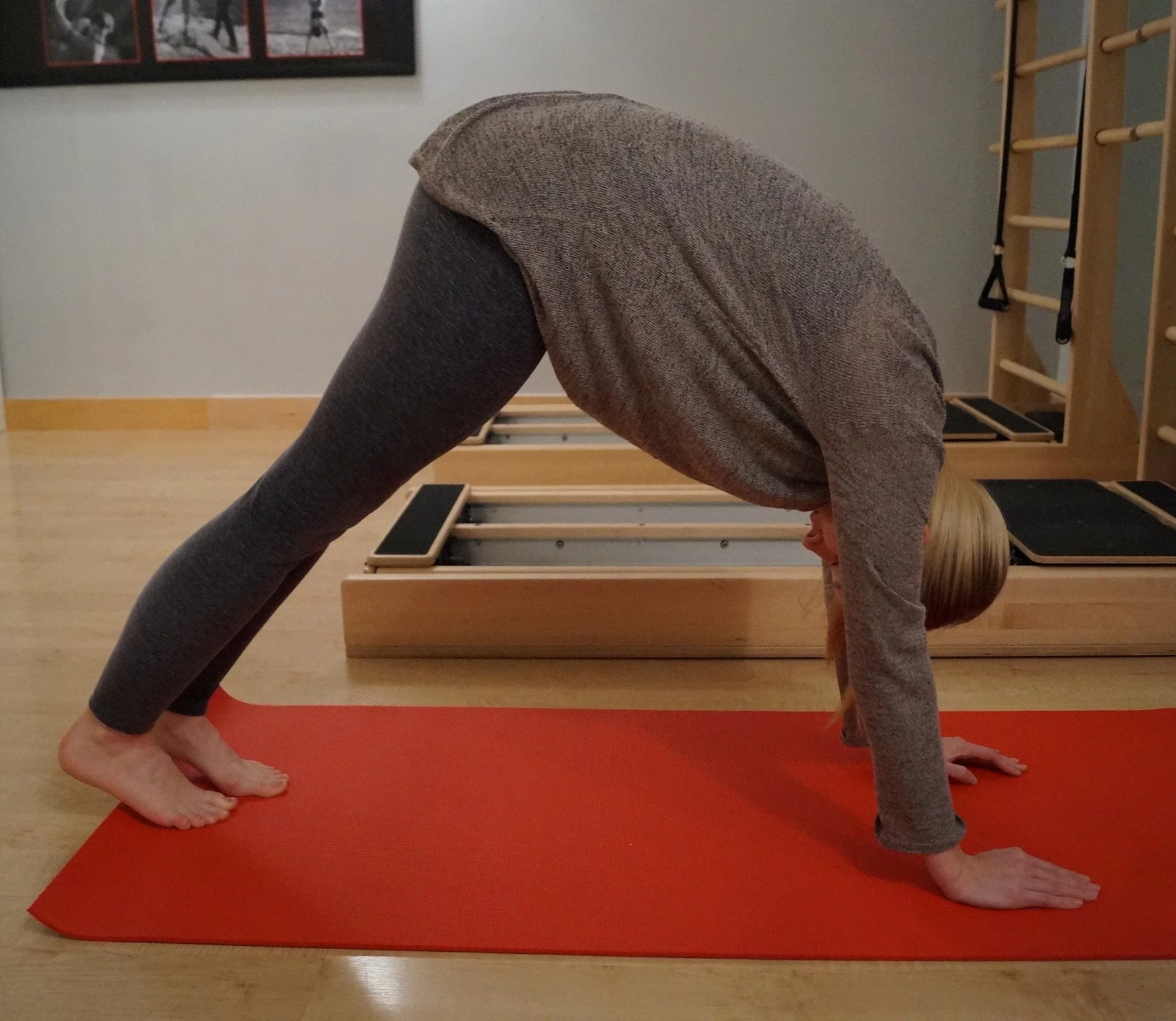 In order to engage core muscles patient is doing a downward dog exercise with a curved back.