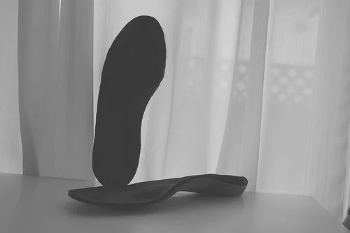 Custom orthotics on a table promoting benefits of orthotics for your feet.